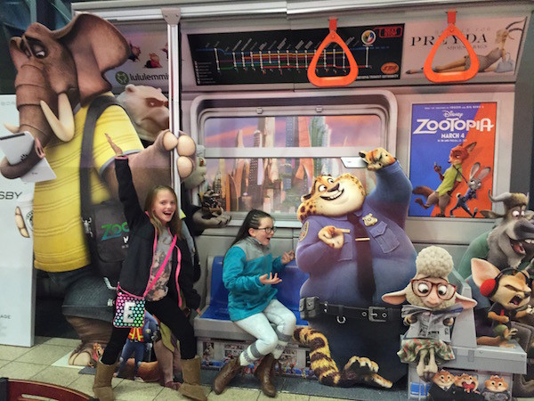 Girls on the Zootopia subway poster.